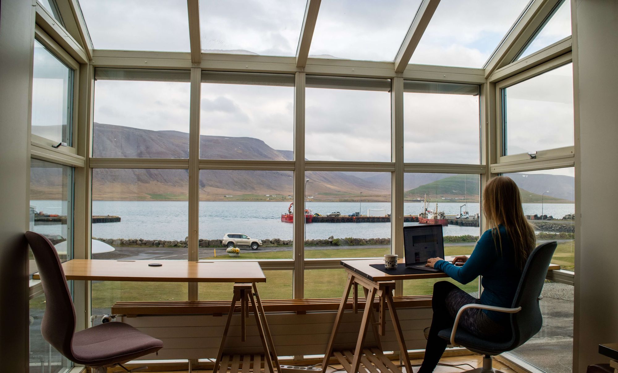 freelance che lavora al computer in una veranda davanti al mare